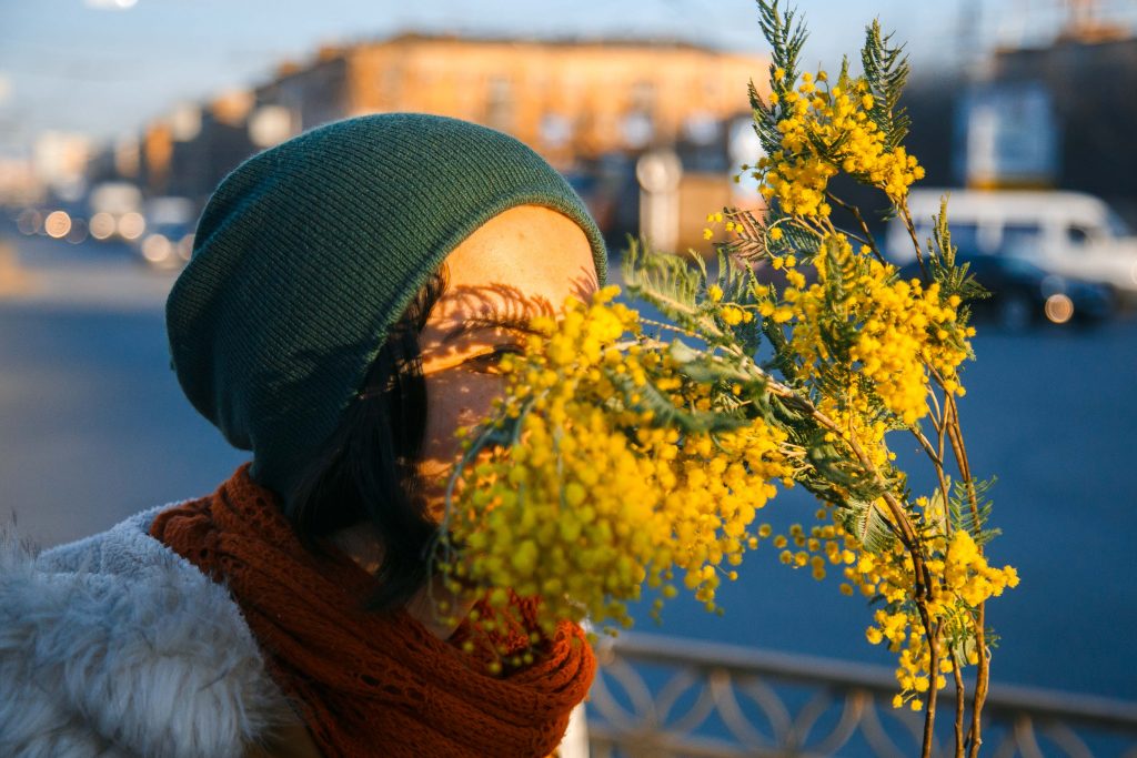 Букет с мимозой женщина в руках